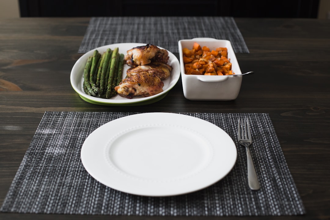 A person practicing caloric restriction vs intermittent fasting, with a clock and a measured meal on a table representing both longevity approaches