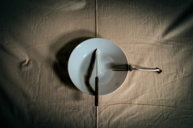 A clean white plate and clock illustrating fasting protocols for longevity and time-restricted eating