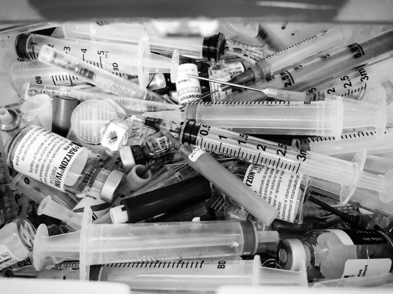 A syringe next to longevity research notes representing GLP-1 drugs and longevity science