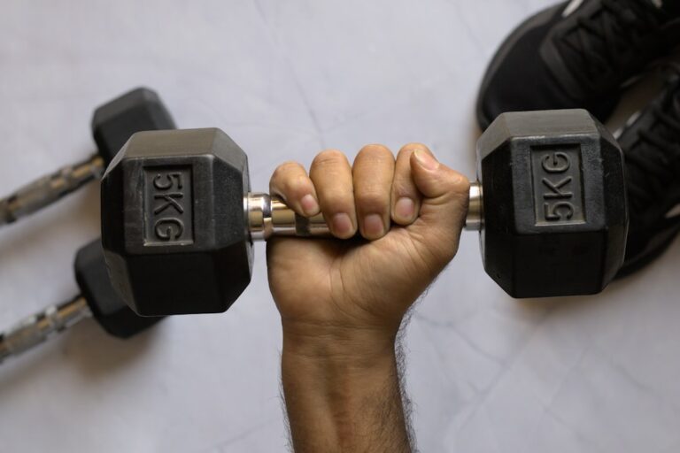 A person performing a grip strength test by age using a hand dynamometer at a fitness facility