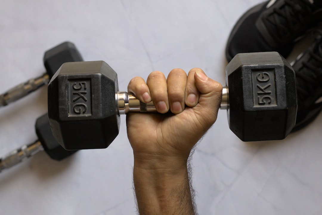 A person performing a grip strength test by age using a hand dynamometer at a fitness facility