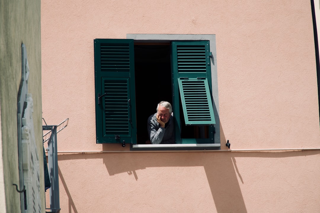 Older adult sitting alone by a window, illustrating the link between loneliness and longevity statistics on aging and mortality risk