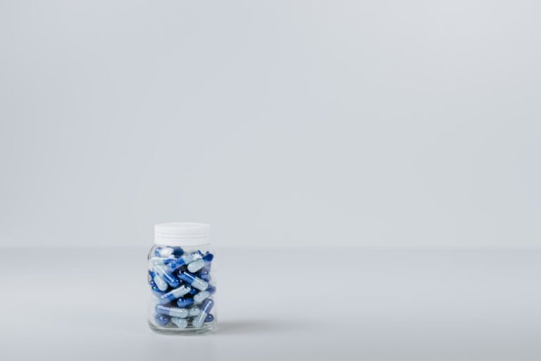 Magnesium threonate vs glycinate supplement capsules side by side on a wooden surface