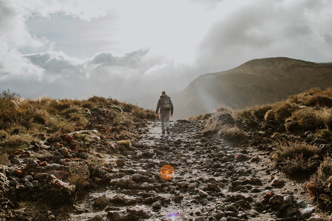 A man rucking on a trail with a weighted backpack, illustrating rucking vs cycling for longevity