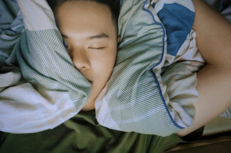 An older adult sleeping peacefully in a dark bedroom, representing optimal melatonin dosage for adults over 50