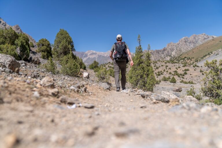 Man over 50 rucking on a trail with a weighted backpack for longevity and fitness