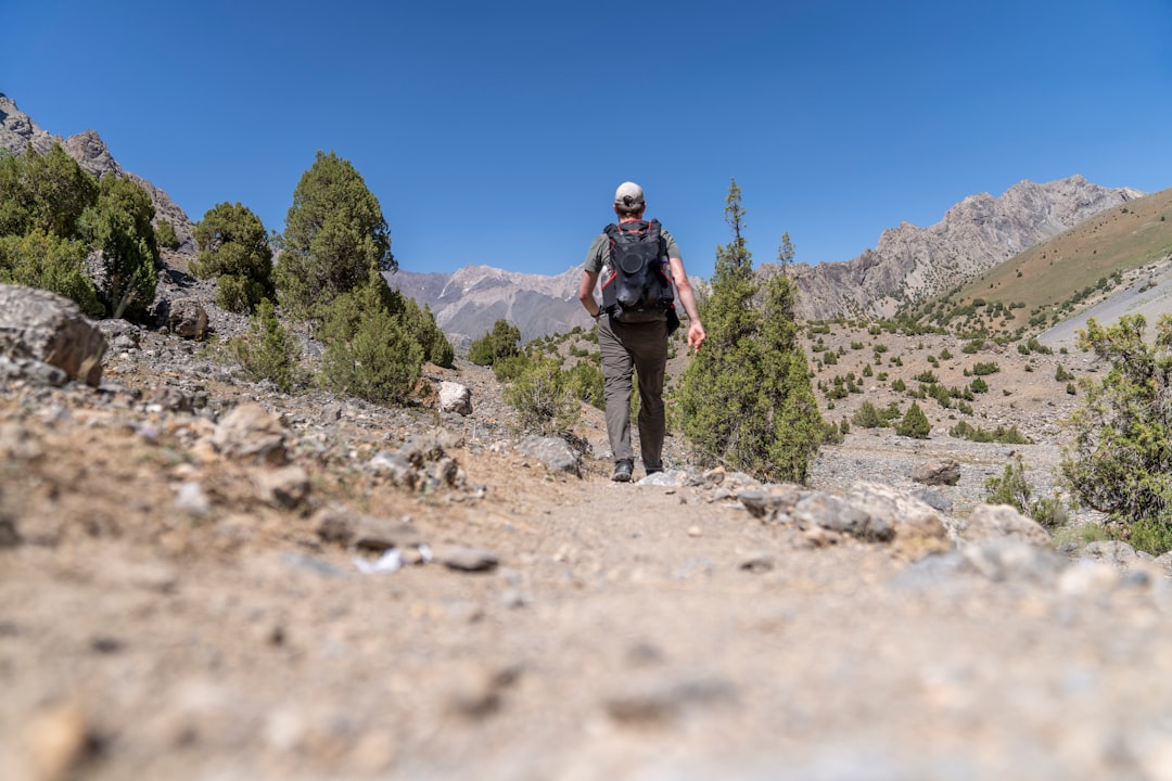 Man over 50 rucking on a trail with a weighted backpack for longevity and fitness