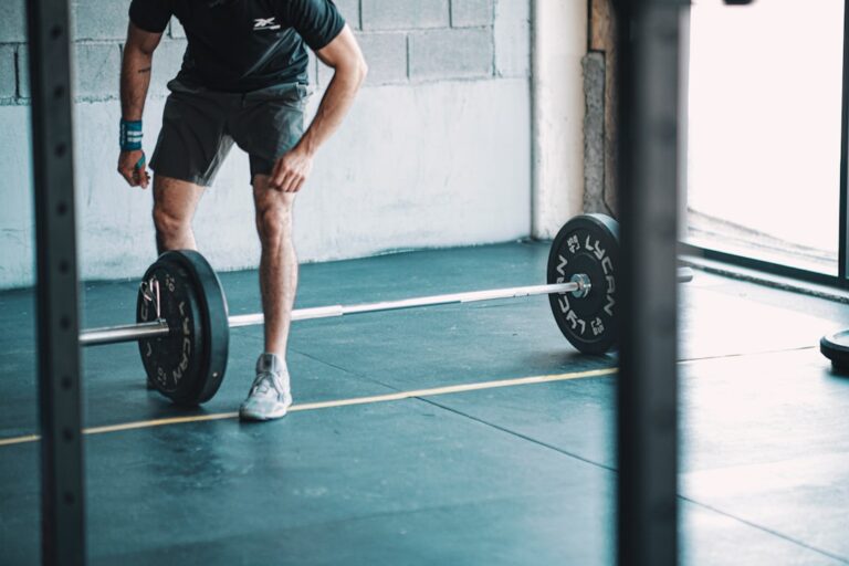 A man in his 40s doing dumbbell exercises at the gym — illustrating early action against sarcopenia warning signs at 40